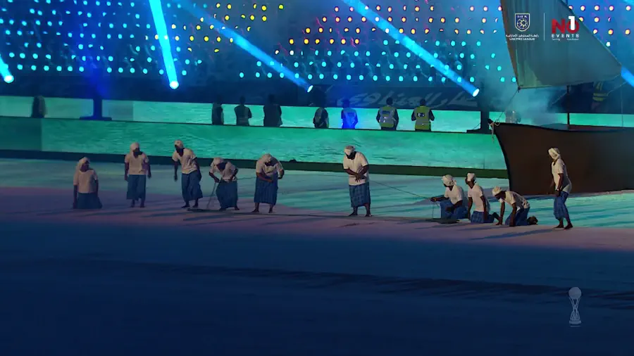 Twelve thousand chair pixels lighting the stands in blue and green behind the performers