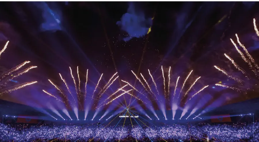 Fireworks and beam fans rising over the stands at Al Awwal Park