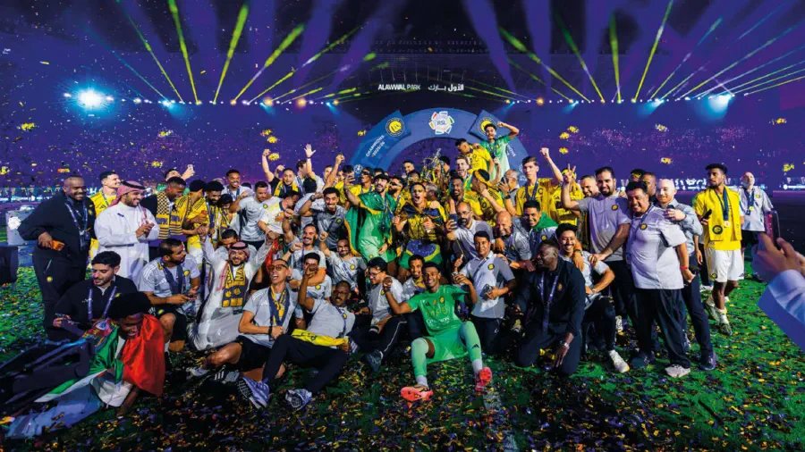 Al Nassr celebrating on the pitch under beams and confetti after the trophy lift